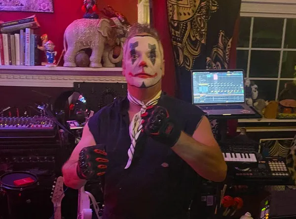 Atom Balm in klown face paint and riding gloves in a studio full of keyboards