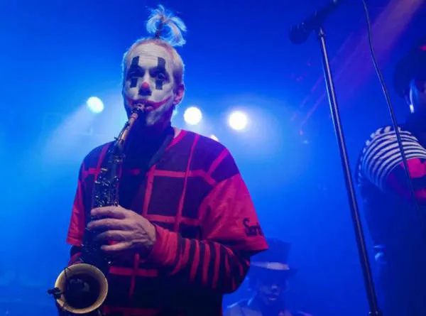 Hobbs playing saxophone under blue stage light